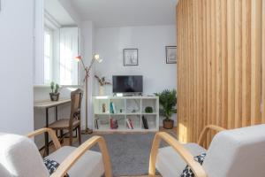 Una sala de estar con televisión, mesa y sillas. en Casas da Couraça, en Coímbra