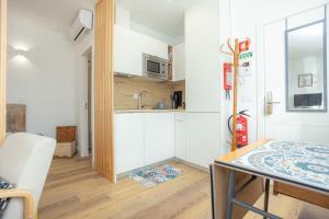 Una pequeña cocina con una mesa y un microondas. en Casas da Couraça, en Coímbra