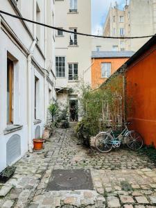 ein Fahrrad, das auf einem steinernen Gehweg neben Gebäuden geparkt ist in der Unterkunft Jolie studio Parisien in Paris