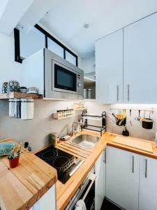 a kitchen with a sink and a microwave at Jolie studio Parisien in Paris