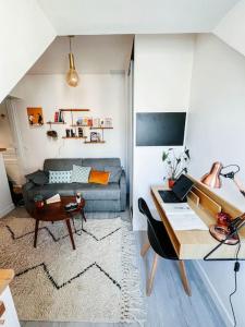 een woonkamer met een bank en een tafel bij Jolie studio Parisien in Parijs