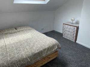 a bedroom with a bed and a wooden dresser at 123a Antrim Road in Belfast