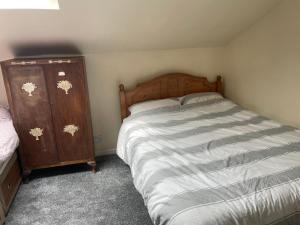 a bedroom with a bed and a wooden dresser at 123a Antrim Road in Belfast