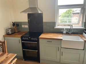 a kitchen with a stove and a sink and a window at 123a Antrim Road in Belfast