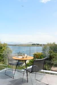 a table and chairs on a balcony with a view of the water at WITHIN THE VILLAGE in Galway