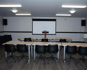 a conference room with a table and chairs and a whiteboard at Travelodge by Wyndham Roberval in Roberval