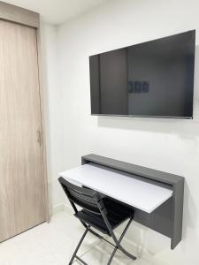 a black and white desk with a television on a wall at Sabaneta Central Nómadas digitales Wi-Fi 202 in Sabaneta