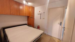 a small room with a bed and wooden cabinets at Residentie Koksijde promenade in Koksijde