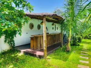 a house with a thatched roof and a palm tree at Keur Ama in Mbour