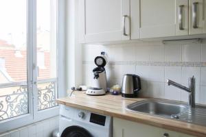 um balcão de cozinha com um lavatório e uma janela em Well Equipped 40m Apartment Near Paris em Le Pré-Saint-Gervais
