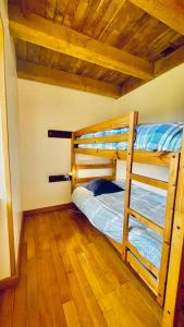a bedroom with two bunk beds and a wooden floor at La petite sirêne in Roscanvel