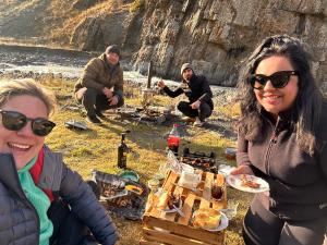 a group of people sitting around a picnic table at Xinaliq Khinalig İzzet's Riverside Home Stay in Xınalıq