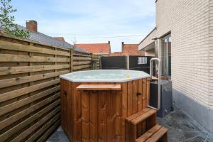 a hot tub sitting on the side of a fence at J and R flanders fields holiday homes in Diksmuide