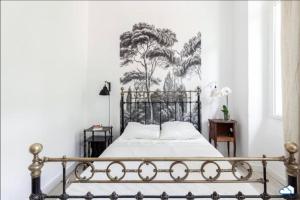 a bedroom with a metal bed with a mural on the wall at Superbe T3 proche Vieux-Port AC in Marseille