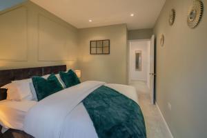 a bedroom with a white bed with green pillows at Four Bed House At Primal Estates Short Lets in Brighton in Brighton & Hove