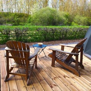 een paar stoelen en een tafel op een houten terras bij Bulle nuage - Etat Nature in Magnières