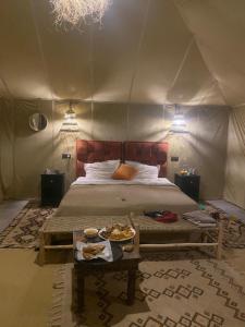 メルズーガにあるMerzouga Luxury Campsのテントベッドルーム(ベッド1台、食料品のトレイ付)