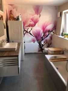 a bathroom with pink flowers on the wall at Stylisches Maybach Appartement mit Terrasse für 5-7 Personen, 5 Betten, große Kochinsel, Homeoffice mit 250Mbit WLAN in Aidlingen