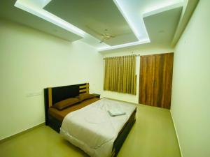 - une chambre blanche avec un lit dans l'établissement AL-Kabeer Heights, à Kazhakuttam