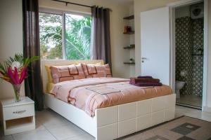 um quarto com uma cama grande e almofadas cor-de-rosa em Acquah Place Residences em Acra