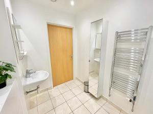 a bathroom with a sink and a shower at Modern Patio Flat close to Sation & Canary Wharf in London