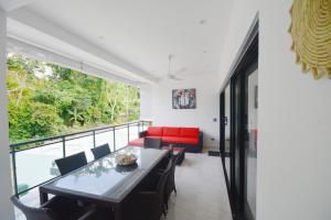 a living room with a table and a red couch at Appartement neuf en loma in Las Terrenas
