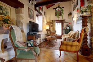 Una sala de estar con televisión, sofá y sillas. en Chez aguirre, en Saint-Jean-Pied-de-Port