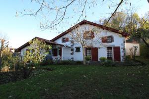 Casa blanca con puertas rojas y patio en Chez aguirre, en Saint-Jean-Pied-de-Port