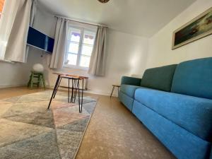 a living room with a blue couch and a table at Ferienwohnung Prinzenhöhe in Herrsching am Ammersee