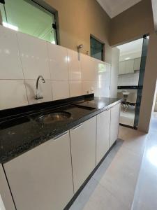 a kitchen with white cabinets and a sink at Casa Maravilhosa em condominio in Luis Eduardo Magalhaes
