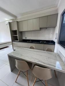 a kitchen with a large marble table and chairs at Casa Maravilhosa em condominio in Luis Eduardo Magalhaes