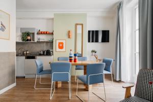 una sala da pranzo con tavolo e sedie blu di Edgar Suites Grands Boulevards - Hauteville a Parigi