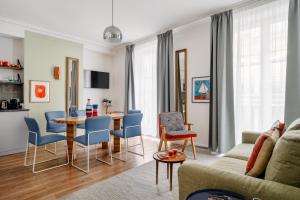 un soggiorno con divano, tavolo e sedie di Edgar Suites Grands Boulevards - Hauteville a Parigi