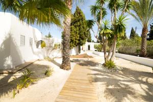 a pathway with palm trees in front of a house at CAN MARTONA in San Antonio Bay