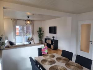 a living room with a table and chairs and a television at Ihr Zuhause fernab von Zuhause in Ringsheim