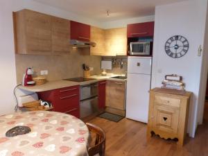 a small kitchen with a table and a white refrigerator at T2 au coeur de Praloup - Le Chanteval in Uvernet