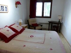 a bedroom with a bed with a red blanket on it at T2 au coeur de Praloup - Le Chanteval in Uvernet