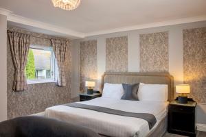 Foxfields Country Hotel في Langho: غرفة نوم بسرير كبير ونافذة