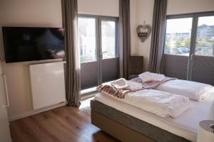 - une chambre avec un lit et une grande fenêtre dans l'établissement Ostsee - Appartement Nr 68 "Utspann" im Strand Resort, à Heiligenhafen