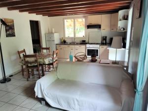 uma sala de estar com um sofá, uma mesa e uma cozinha em Gambade em Sainte-Eulalie-en-Born