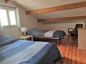 um quarto com 2 camas, uma cadeira e uma janela em Gambade em Sainte-Eulalie-en-Born