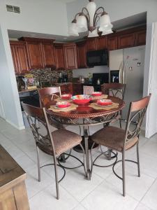 a kitchen with a table and chairs with bowls on it at Pily's Vintage Stay Room Full Bed in Orlando