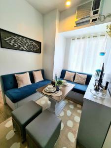 uma sala de estar com um sofá azul e uma mesa em Slice of Paradise La Bella Residences em Tagaytay