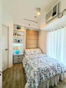 a bedroom with a bed and a window at Slice of Paradise La Bella Residences in Tagaytay