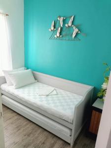 uma cama num quarto com uma parede azul em Slice of Paradise La Bella Residences em Tagaytay