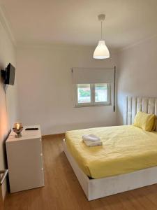 - une chambre blanche avec un lit et une table dans l'établissement Extraordinary Holiday House at Fernão Ferro!, à Fernão Ferro