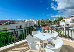 einen Balkon mit einem weißen Tisch und Stühlen in der Unterkunft Apartamentos Parque del Sol in Adeje