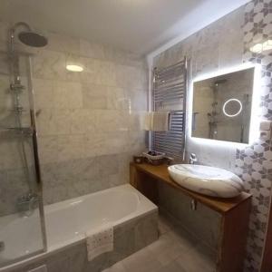 uma casa de banho com uma banheira e um lavatório e uma banheira em Apartmány & Wellness Revenite em Jeseník