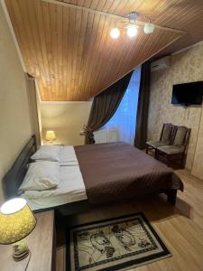 a bedroom with a bed and a chair and a window at Lileya Hotel in Polyana