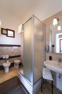 een badkamer met een douche, een wastafel en een toilet bij Kòre rooms in Castellammare del Golfo